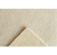 Gros plan de la texture d un tapis en feutre aiguilleté beige avec un coin replié.