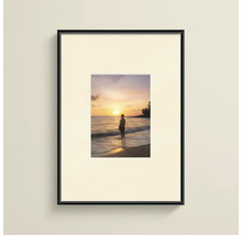 Cadre photo noir avec passe-partout et impression d'un coucher de soleil sur la plage.