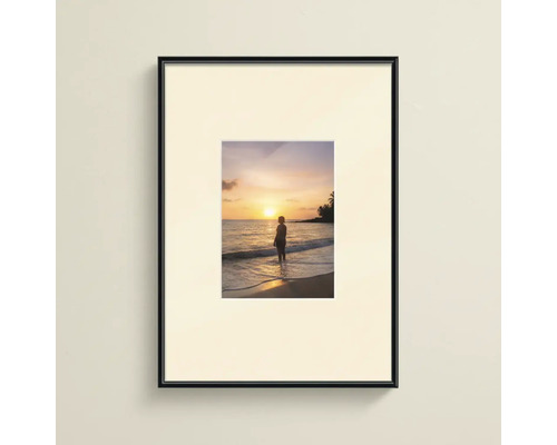 Cadre photo noir avec passe-partout et impression d'un coucher de soleil sur la plage.