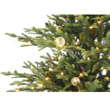 Künstlicher Weihnachtsbaum mit warmweißer LED-Beleuchtung und dekorativen Glaskugeln.