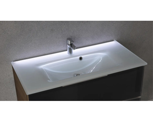 Glaswaschtisch mit integrierter LED-Beleuchtung, verchromter Armatur und dunklem Waschtischunterschrank.