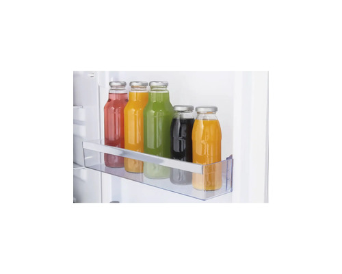 Bouteilles en verre avec des liquides colorés dans un balconnet de porte de réfrigérateur transparent.