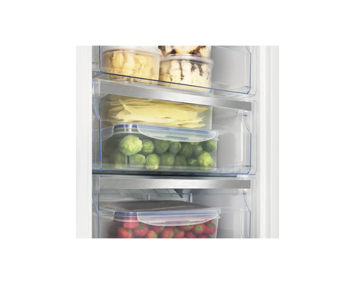 Congélateur avec aliments organisés de manière claire dans des tiroirs transparents tels que choux de Bruxelles et fraises.