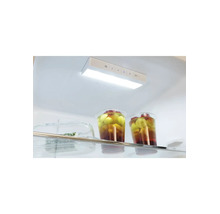Intérieur clair et organisé d'un réfrigérateur avec éclairage LED et panneau de commande de température au-dessus d'une clayette en verre.