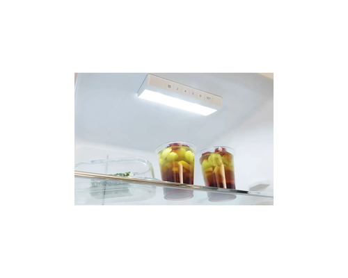 Intérieur clair et organisé d'un réfrigérateur avec éclairage LED et panneau de commande de température au-dessus d'une clayette en verre.