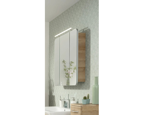 Armoire de toilette à trois portes avec éclairage LED et éléments en bois dans une salle de bains lumineuse au style moderne.