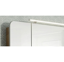 Armoire de toilette avec éclairage LED et angles arrondis devant un mur tapissé.