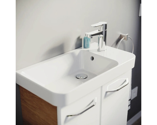Meuble de salle de bain moderne avec vasque en céramique blanche, mitigeur chromé et meuble blanc avec décor bois latéral.