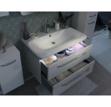 Meuble sous-vasque blanc moderne avec deux tiroirs ouverts, éclairage LED intégré et armoire latérale assortie dans une salle de bains organisée.