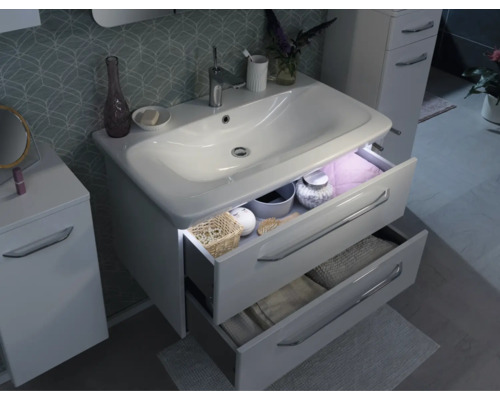 Meuble sous-vasque blanc moderne avec deux tiroirs ouverts, éclairage LED intégré et armoire latérale assortie dans une salle de bains organisée.