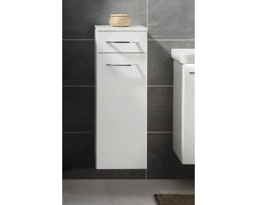 Meuble de salle de bain suspendu blanc avec tiroir et porte, poignées chromées, fixé sur un mur avec du carrelage sombre.