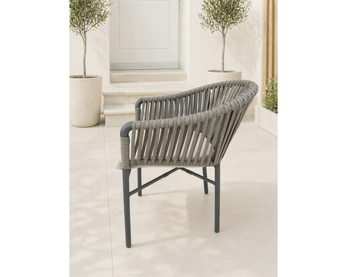 Moderner Gartenstuhl mit Seilgeflecht und Metallgestell auf einer hellen Terrasse mit Olivenbäumen.