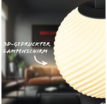 Nahaufnahme eines dreidimensional gedruckten Lampenschirms mit gewellter Struktur in einem Wohnzimmer.