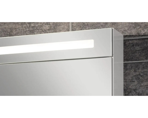 Vue détaillée d'une armoire de toilette avec éclairage LED intégré sur le dessus.