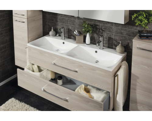 Double vasque avec meuble sous-vasque aspect bois, deux tiroirs et lavabo en céramique blanche devant un mur de carrelage sombre.