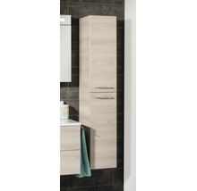 Armoire haute de salle de bain aspect bois avec deux portes et poignées métalliques montée sur un mur carrelé.