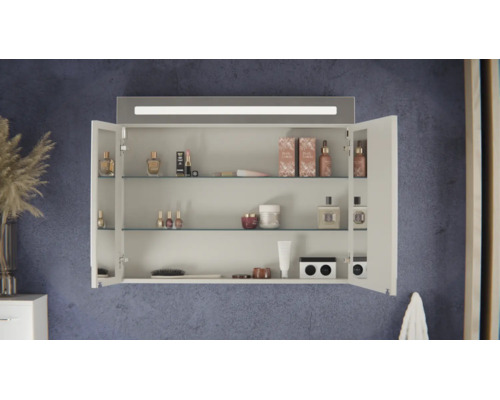 Geöffneter Badezimmer-Spiegelschrank mit integrierter LED-Beleuchtung, drei Glaseinlegeböden und diversen Kosmetikprodukten an einer Wand.