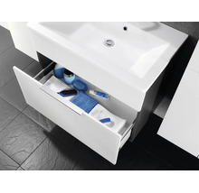 Moderner Waschbeckenunterschrank mit Keramikbecken und geöffneter Schublade mit Badutensilien und Handtüchern.