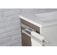 Porte-serviettes télescopique à deux barres en métal, monté sur un meuble de salle de bains aspect bois à côté d'un lavabo blanc.