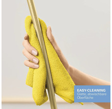 Une main nettoie une barre métallique lisse avec un chiffon jaune. Fonction Easy-Cleaning pour surfaces lavables.