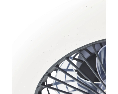 Vue détaillée d'un plafonnier avec ventilateur, abat-jour blanc à effet étoilé et grille de protection foncée.