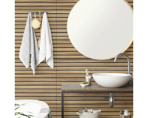 Revêtement mural aspect bois avec lattes horizontales dans une salle de bains moderne et lumineuse avec miroir rond et vasque blanche.