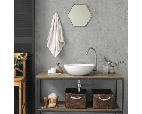 Modernes Badezimmer mit rundem Aufsatzwaschbecken, hoher Armatur und Waschtisch aus Holz und Metall. Über dem Becken hängt ein sechseckiger Spiegel.