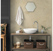 Salle de bain moderne avec vasque à poser blanche sur meuble en bois, robinet haut, miroir hexagonal et paniers de rangement.