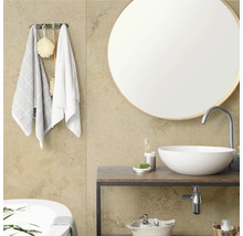 Salle de bain moderne avec miroir rond, vasque à poser sur un meuble en bois et crochets à serviettes avec accessoires.