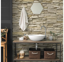 Salle de bains moderne avec parement mural en pierre structurée, lavabo à poser sur une étagère en bois et miroir hexagonal.