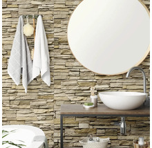 Salle de bain avec parement mural aspect pierre naturelle, miroir rond, plan vasque en bois et vasque à poser blanche.