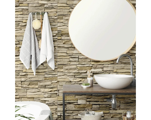 Salle de bain avec parement mural aspect pierre naturelle, miroir rond, plan vasque en bois et vasque à poser blanche.