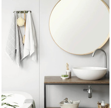 Modernes, helles Badezimmer mit rundem Spiegel, weißem Aufsatzwaschbecken auf Holzwaschtisch und Handtuchhalter mit Textilien.