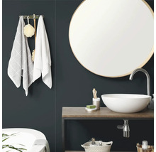 "Salle de bains moderne avec miroir mural rond, vasque  poser blanche sur plateau en bois et porte-serviettes."