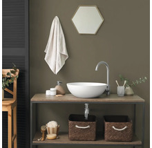 Salle de bain moderne avec vasque à poser blanche sur meuble en bois, robinet argenté et paniers de rangement tressés.