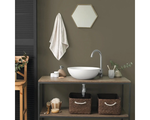 Salle de bain moderne avec vasque à poser blanche sur meuble en bois, robinet argenté et paniers de rangement tressés.