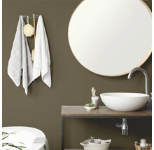 Salle de bains moderne avec mur vert olive, miroir rond avec cadre en bois, vasque à poser blanche sur meuble sous-vasque en bois et serviettes.