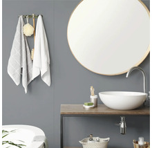 Salle de bain moderne avec miroir rond, vasque à poser blanche sur plan de toilette en bois, mur gris et patère avec serviettes.