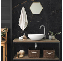 Salle de bains moderne avec vasque à poser blanche, plan en bois, mur en marbre sombre, miroir hexagonal et paniers de rangement tressés.