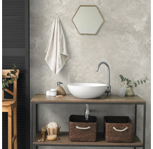 Modernes Badezimmer mit rundem Aufsatzwaschbecken auf einem Holzwaschtisch, Sechskantspiegel, Handtuch und Aufbewahrungskörben aus Geflecht.