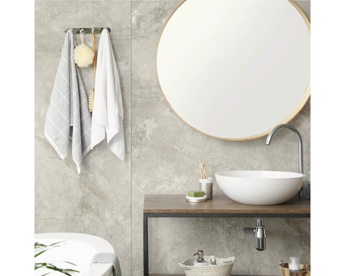 Modernes Badezimmer mit rundem Spiegel, weißem Aufsatzwaschbecken auf Holzkonsole, grauen Fliesen in Marmoroptik und Handtuchhalter.