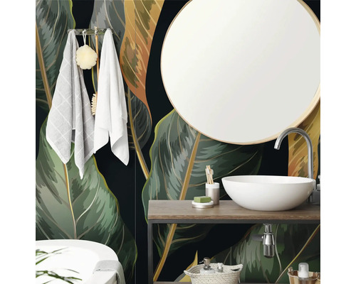 Salle de bain moderne avec papier peint intissé au motif de feuilles tropicales, vasque à poser blanche, miroir rond et meuble en bois.