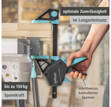 Wolfcraft Einhandzwinge PRO fixiert ein Holzbrett auf einer Werkbank, kontrolliertes Spannen mit bis zu 150 Kilogramm Spannkraft.