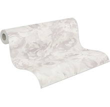 Papier peint intissé à grand motif floral, rouleau partiellement déroulé.