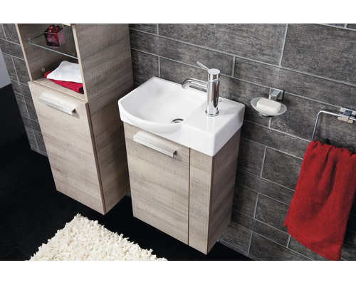 Salle de bain moderne avec meuble sous lavabo et armoire haute aspect bois, lavabo en céramique et carrelage sombre.