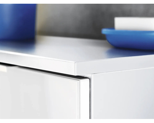 Gros plan sur un meuble de salle de bain blanc avec une surface lisse, un tiroir et des accessoires de salle de bain.