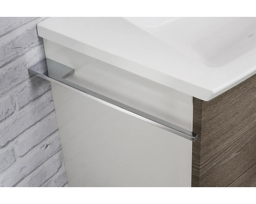Meuble sous-vasque pour salle de bains avec lavabo intégré et porte-serviettes en métal monté sur le côté.