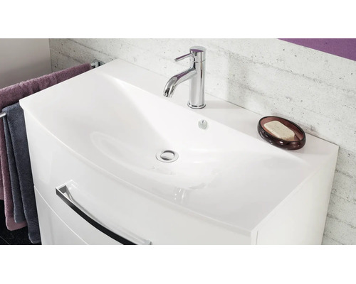 Meuble sous-lavabo moderne blanc avec vasque intégrée, robinetterie chromée et grande poignée sur le tiroir.