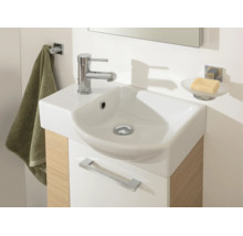 Petit lavabo moderne avec robinet chromé sur un meuble sous-vasque aspect bois avec crochet à serviette et porte-savon.