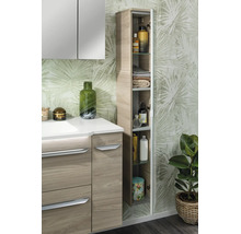 Salle de bains moderne avec meuble sous vasque aspect bois, armoire de toilette et colonne ouverte devant un papier peint à motif de feuilles.